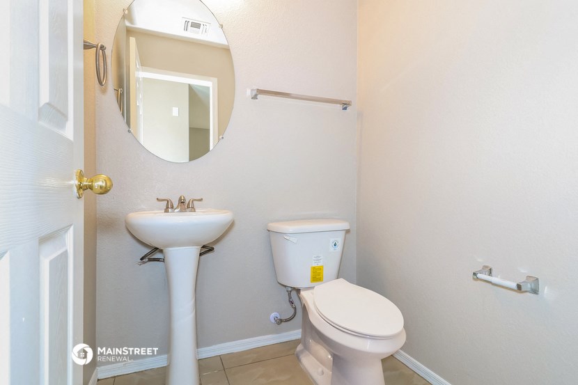 a bathroom with a toilet and a sink and a mirror