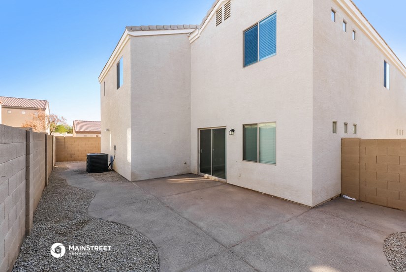 a large white house with a driveway and a gate