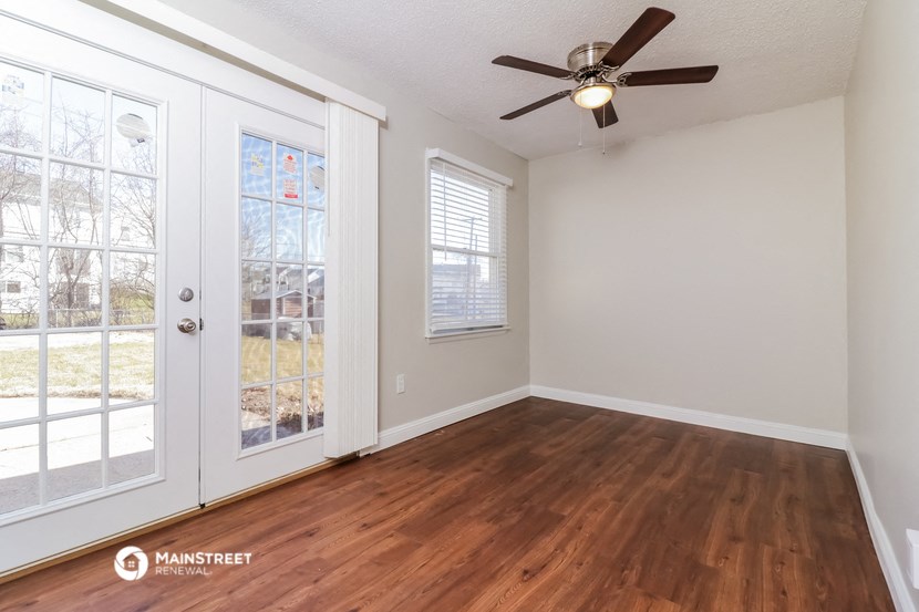 the living room of an empty house with a ceiling fan