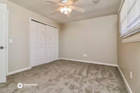 the living room of a manufactured home with carpet and a ceiling fan