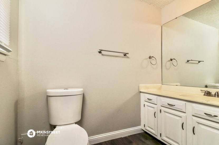 a bathroom with white cabinets and a toilet and a sink