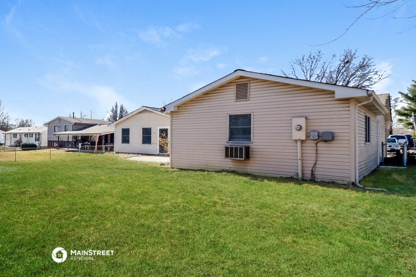 a small white house with a yard in front of it