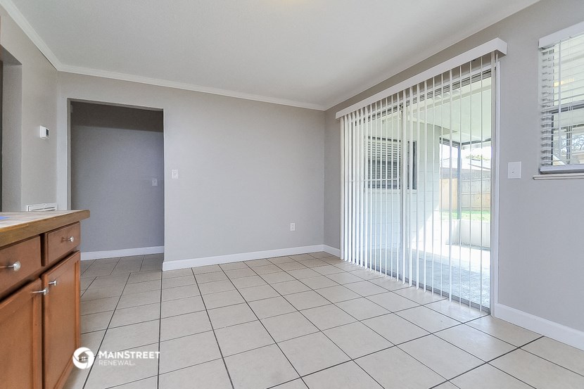an empty living room with a sliding glass door to a patio