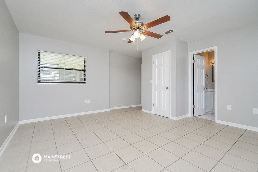 the living room has a ceiling fan and a tiled floor