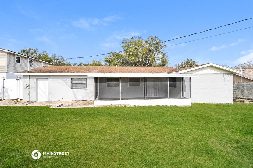 a small white house with a grass yard and a garage