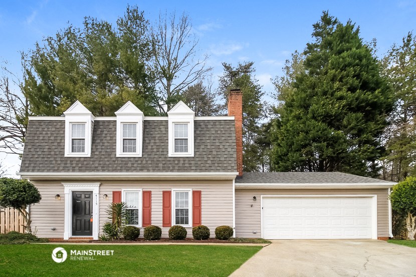 a white house with red shutters and a gray roof