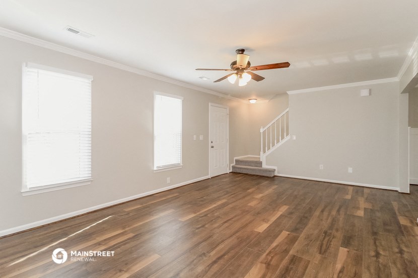 the living room with hardwood floors and a ceiling fan