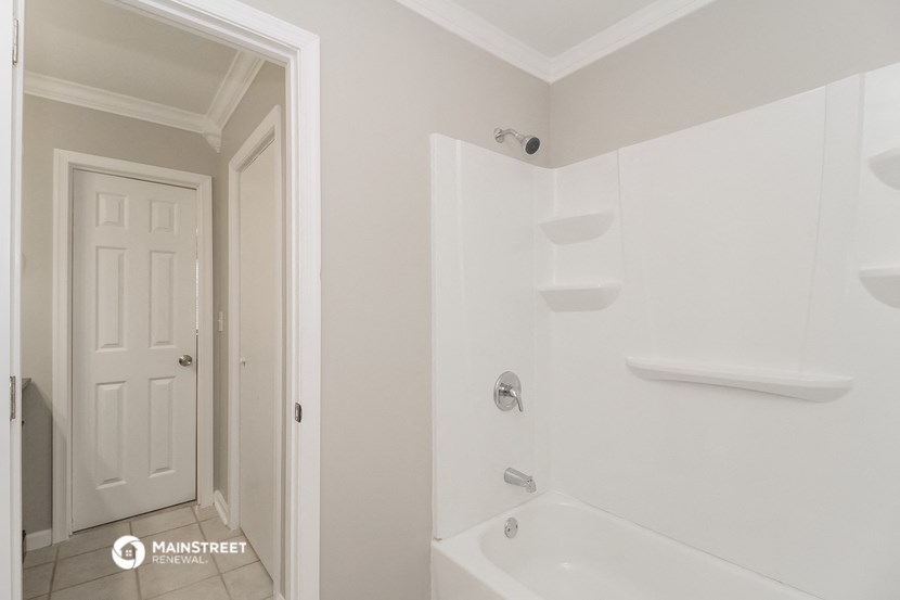 a bathroom with a tub and a shower and a door