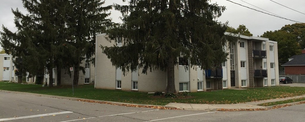 a row of white apartment buildings on the side of a street