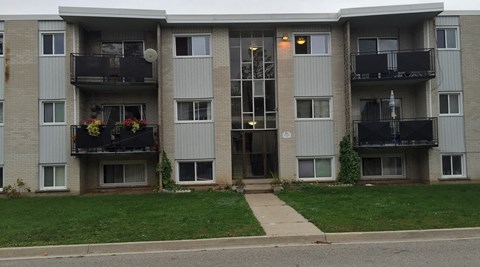 an apartment building with balconies and a sidewalk