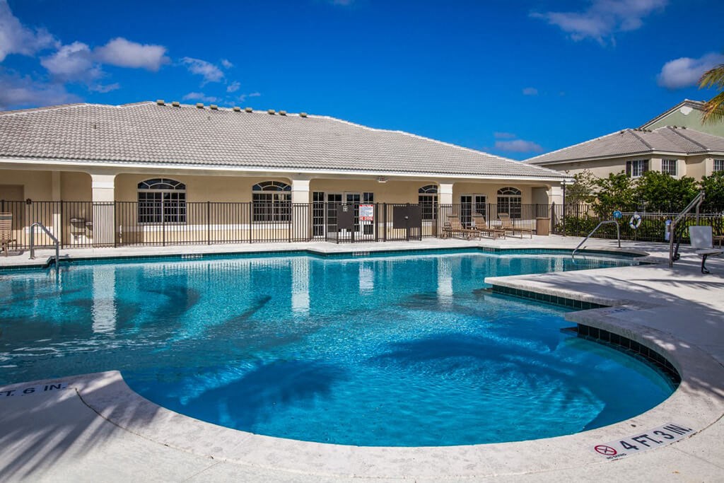 a swimming pool with a house in the background