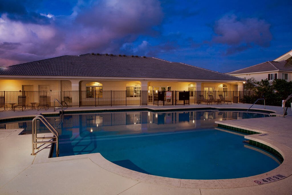 a swimming pool with a house in the background