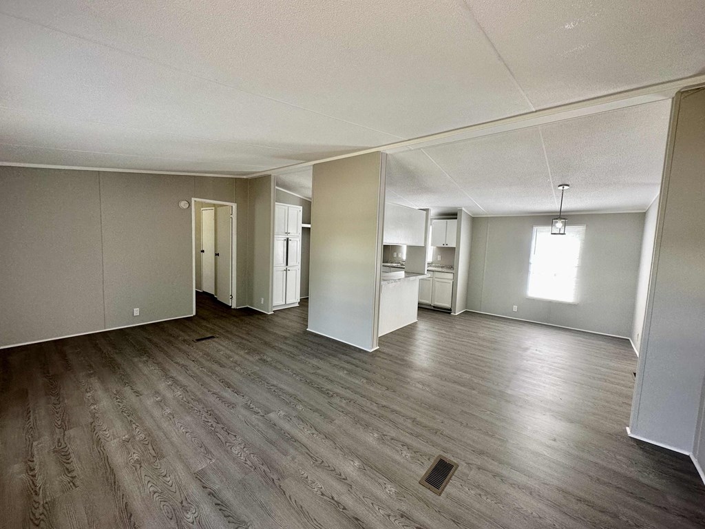 an empty living room with white walls and wood floors