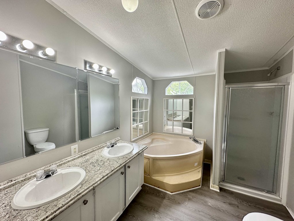 a bathroom with two sinks and a tub and a shower