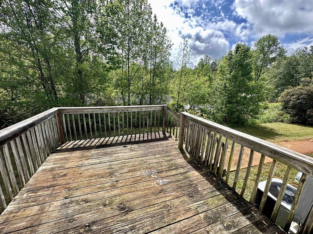 a wooden deck with trees in the background