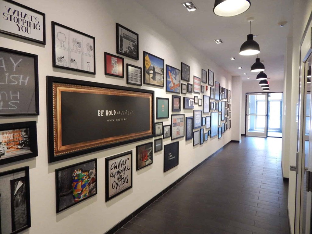 a gallery wall of framed pictures on the wall of a hall