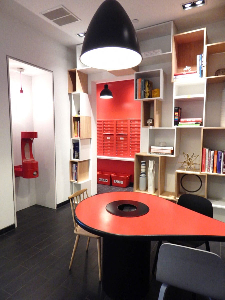 an office with a red desk and a bookshelf