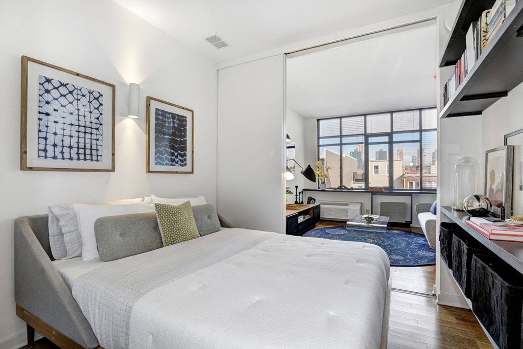 a bedroom with a bed and a large window