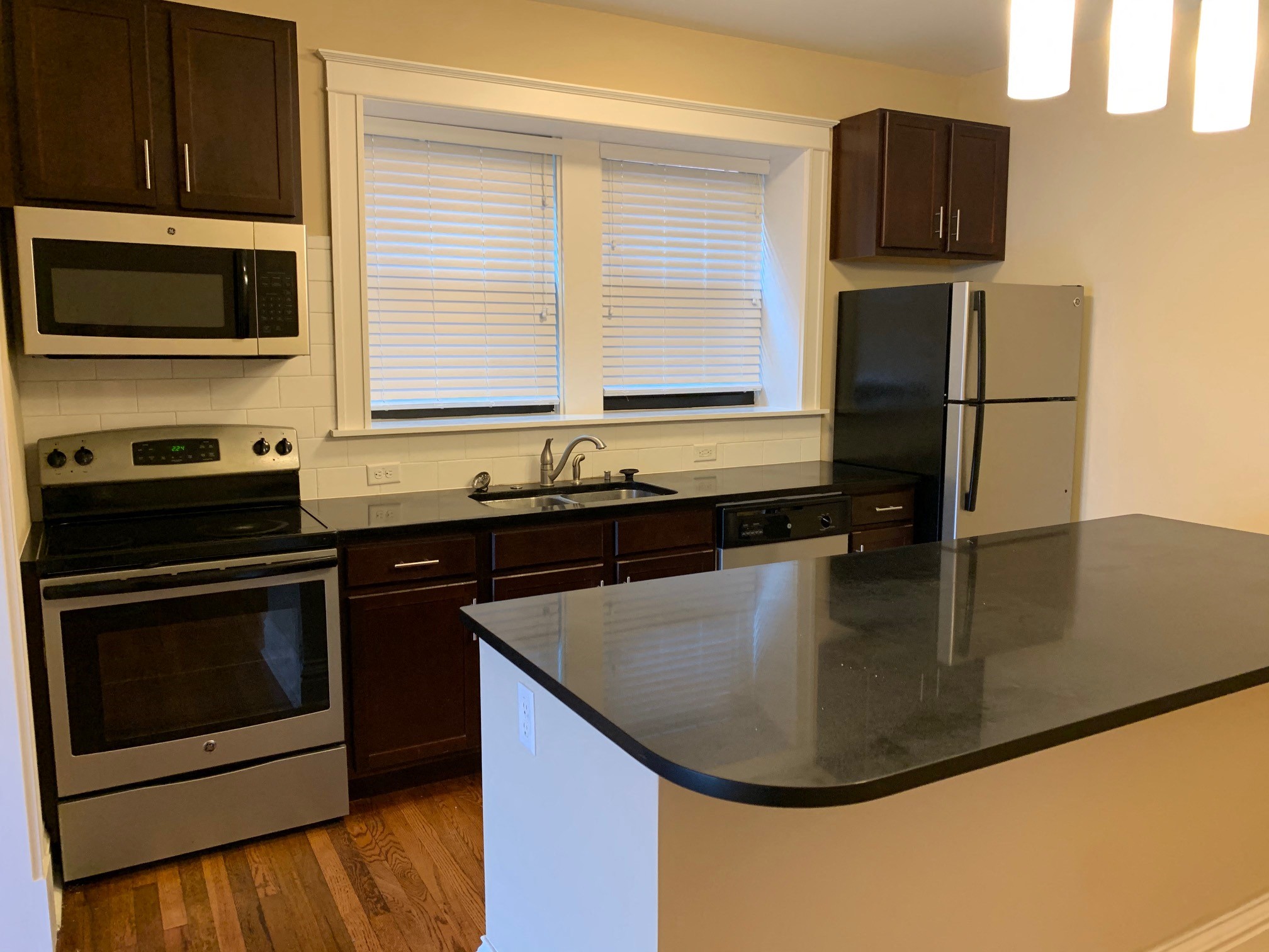 a kitchen with black counter top and stainless steel appliances