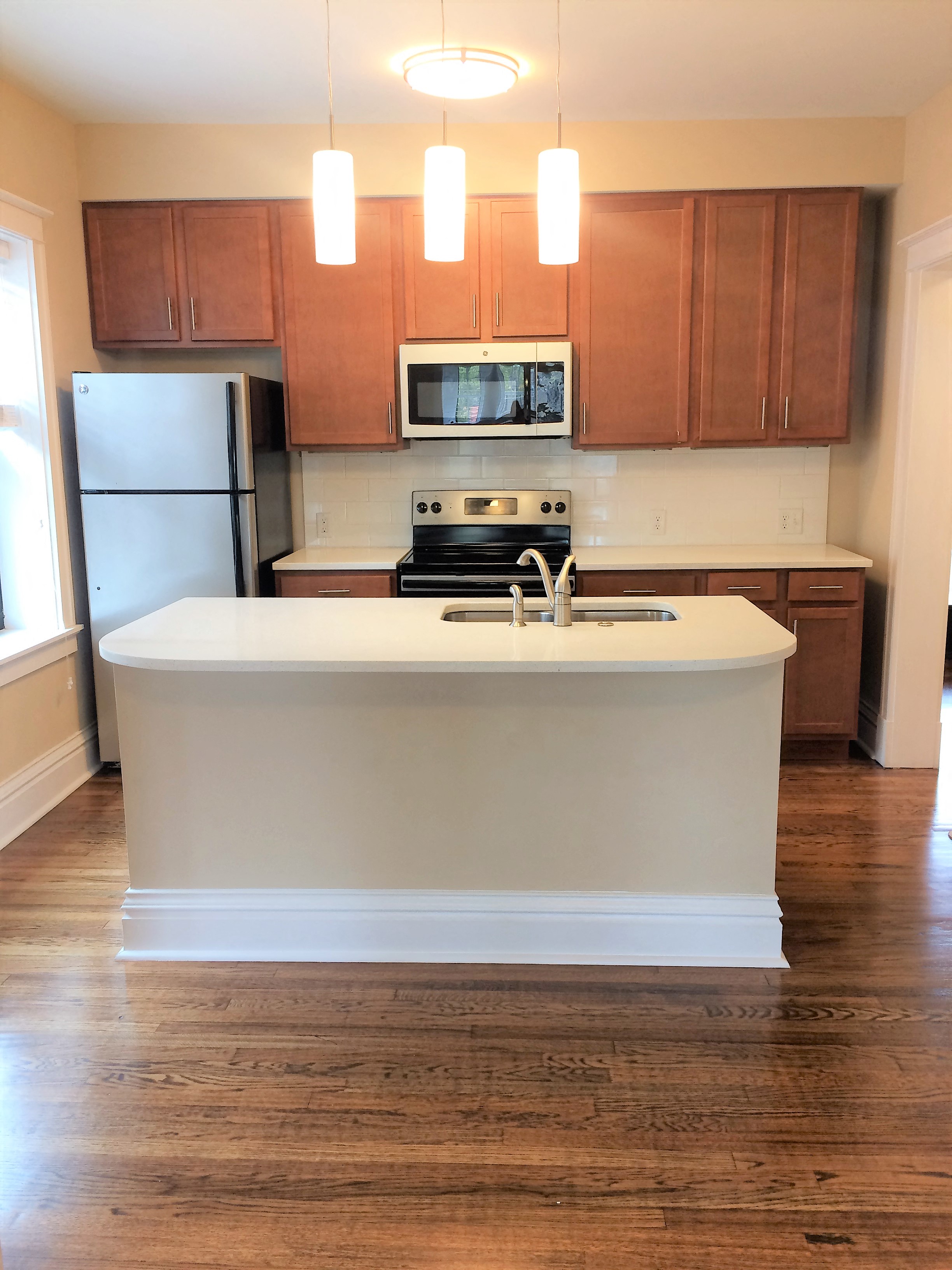 a kitchen with a white island and wooden cabinets