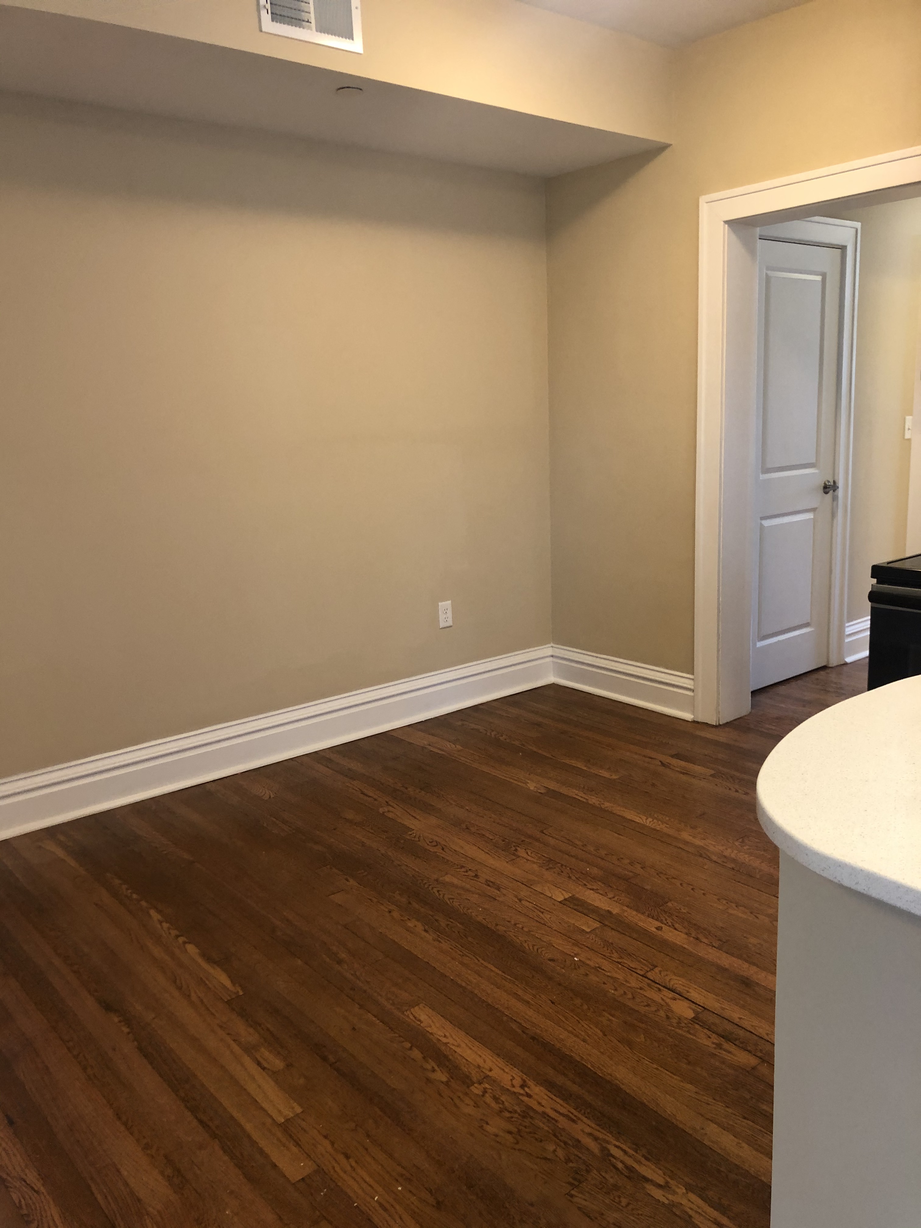 a living room with wooden floors and a white door