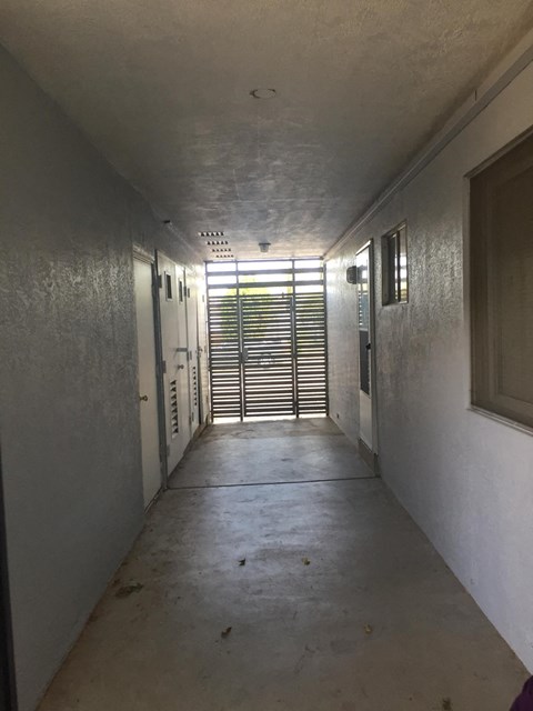 A long, narrow hallway with a door at the end.