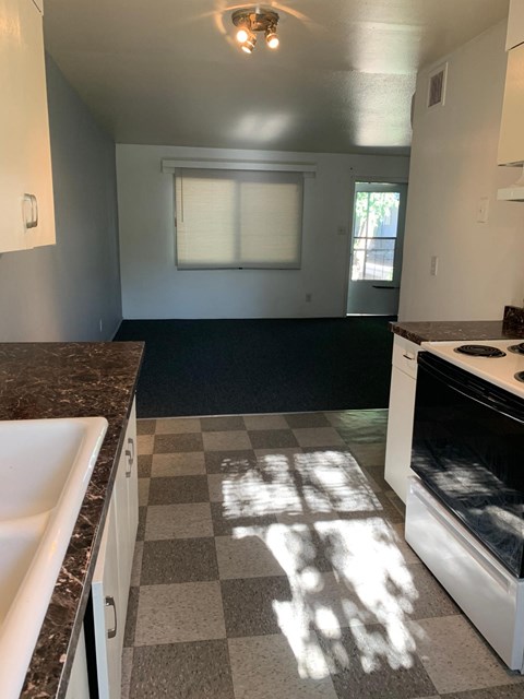 A kitchen with a checkered floor and a white oven.