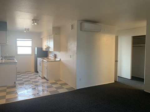 A kitchen with a checkered floor and white walls.