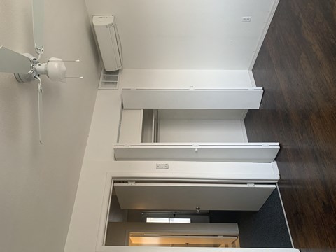 A white ceiling fan is mounted on a white wall.