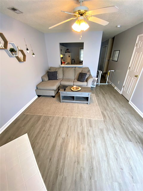 A living room with a beige couch and a white coffee table.