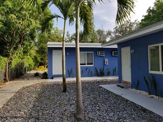 a blue house with palm trees in front of it