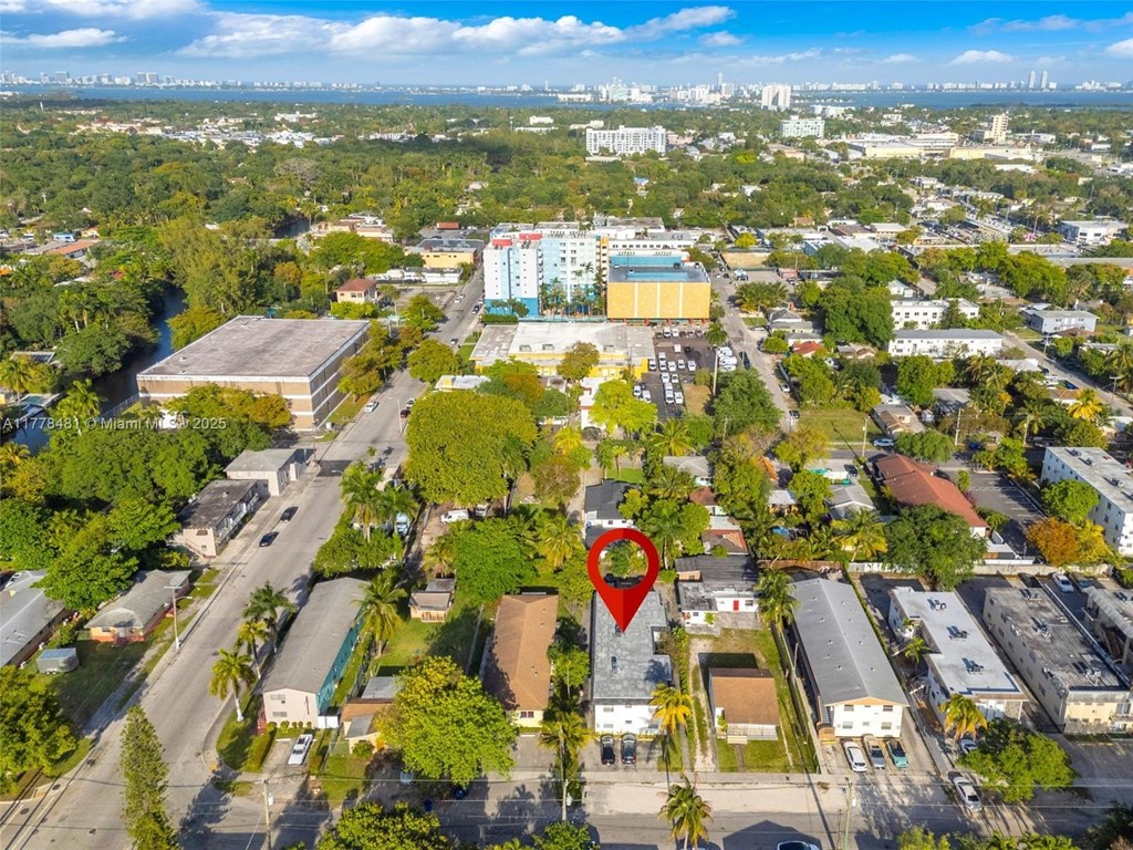 An aerial view of a city with a red pin on a building.