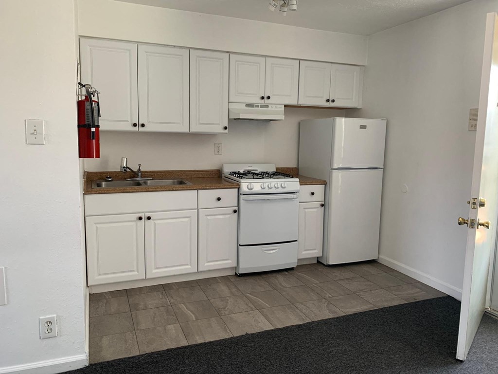 a kitchen with a stove refrigerator and sink