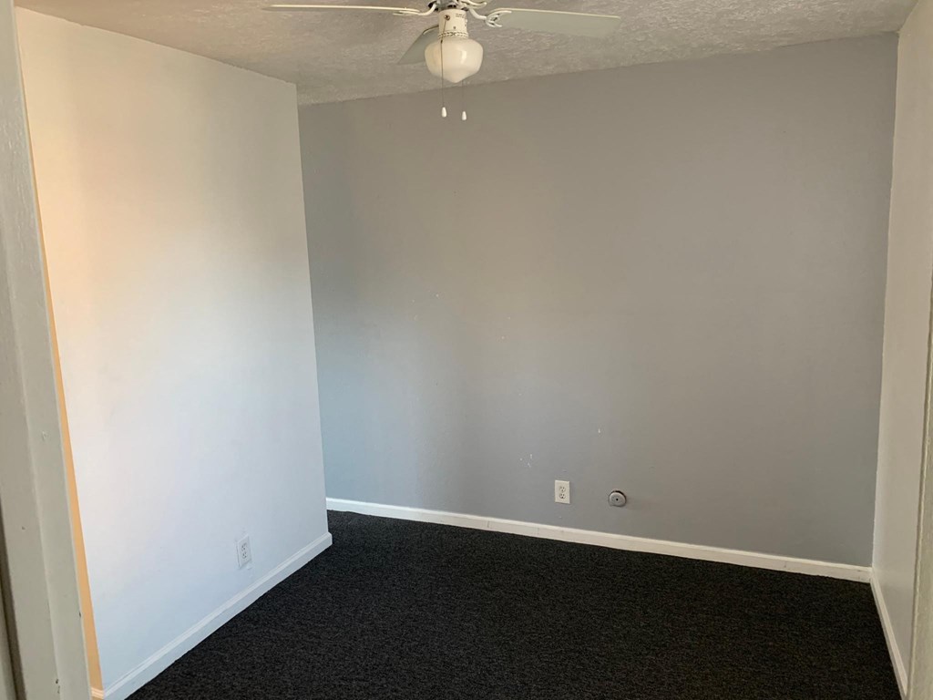a room with white walls and a ceiling fan