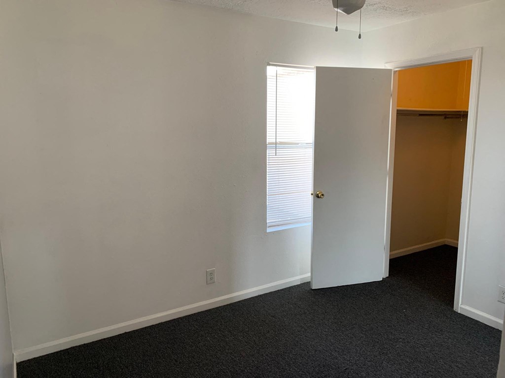 an empty room with a door and a window