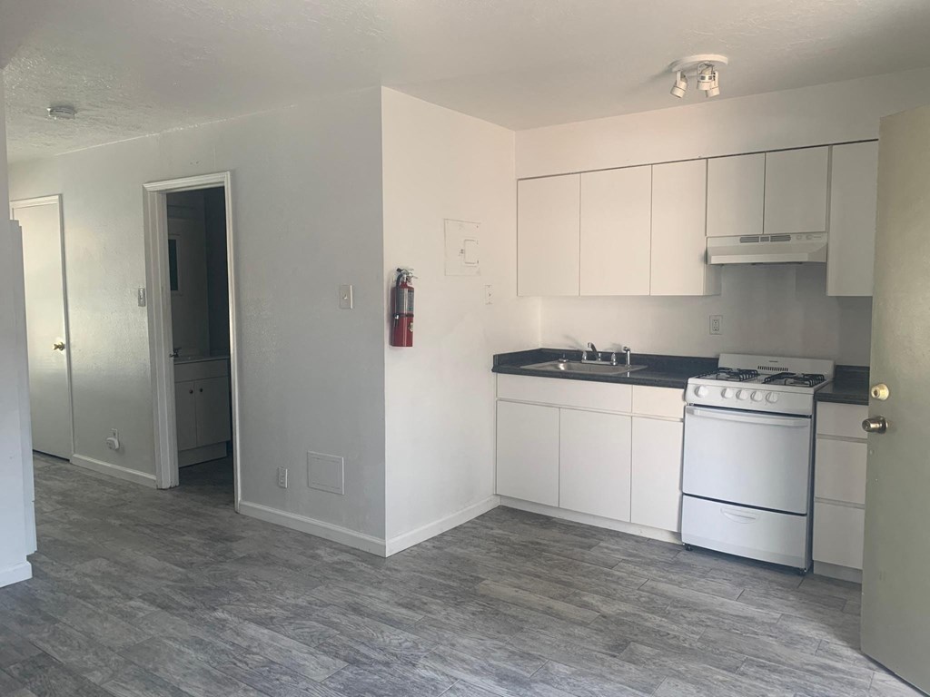 a kitchen with white cabinets and a stove and a sink