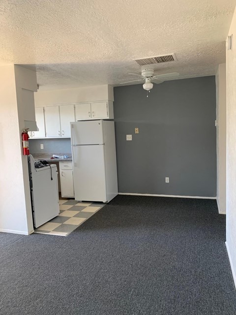A kitchen with a refrigerator and cabinets.