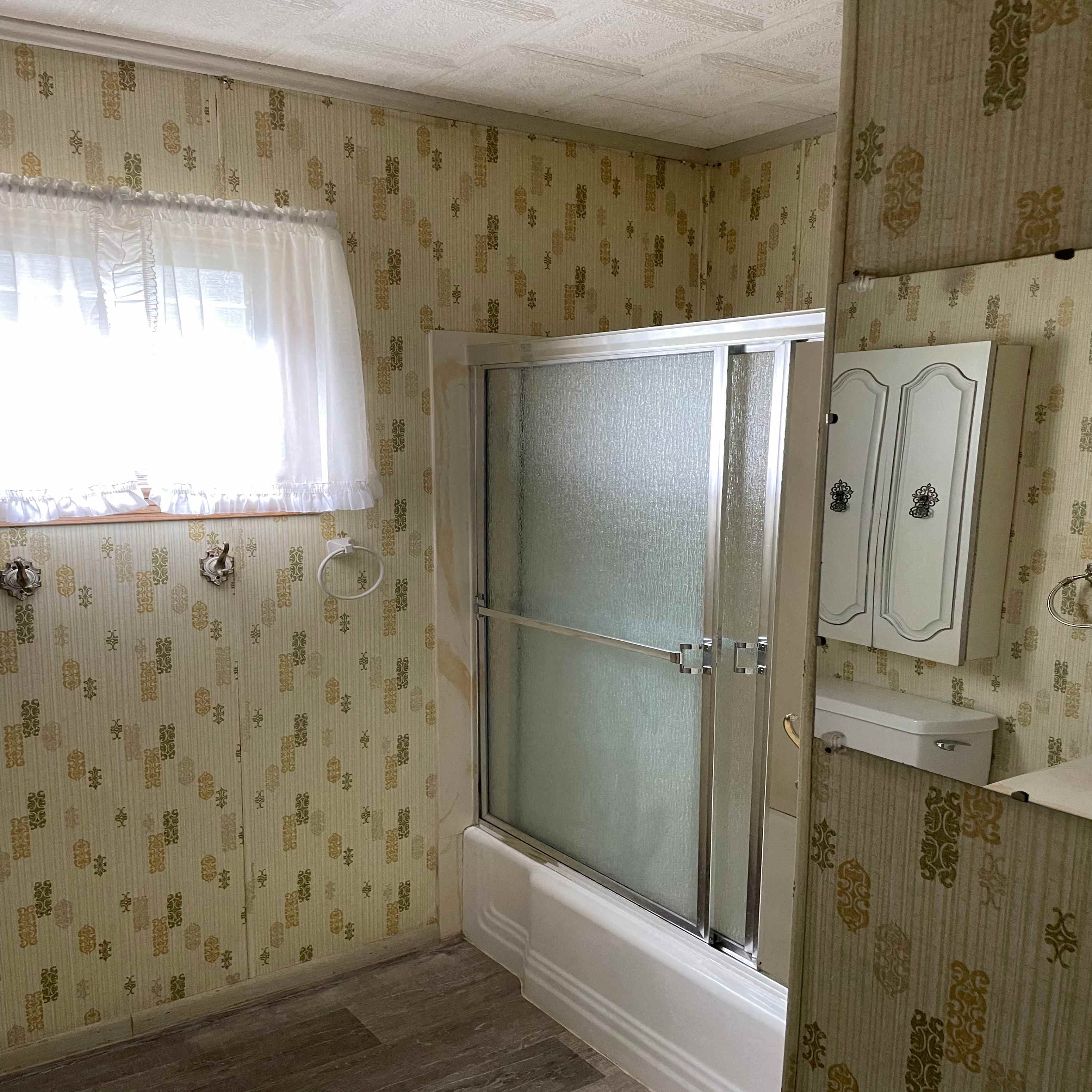 a bathroom with a shower and a sink and a window