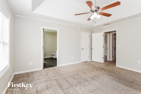 a living room with carpet and a ceiling fan