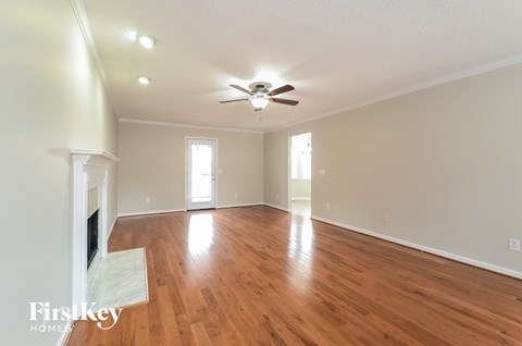 A spacious room with wooden floors and a fireplace.