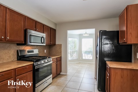 a kitchen with wooden cabinets and a black refrigerator and stove