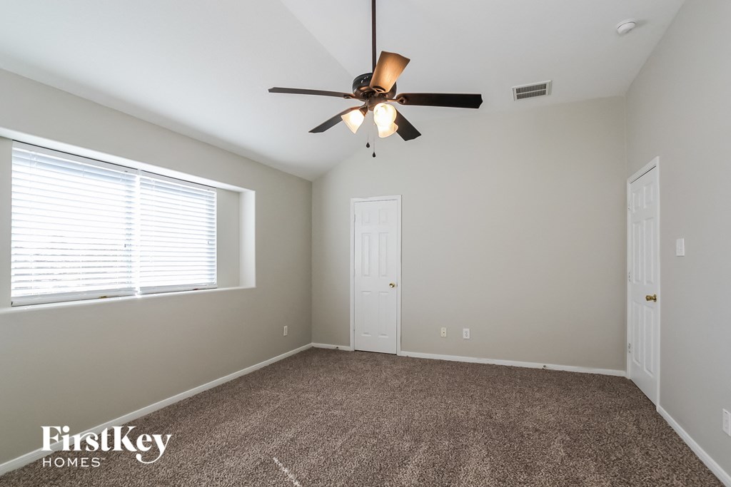 a bedroom with a ceiling fan and a window