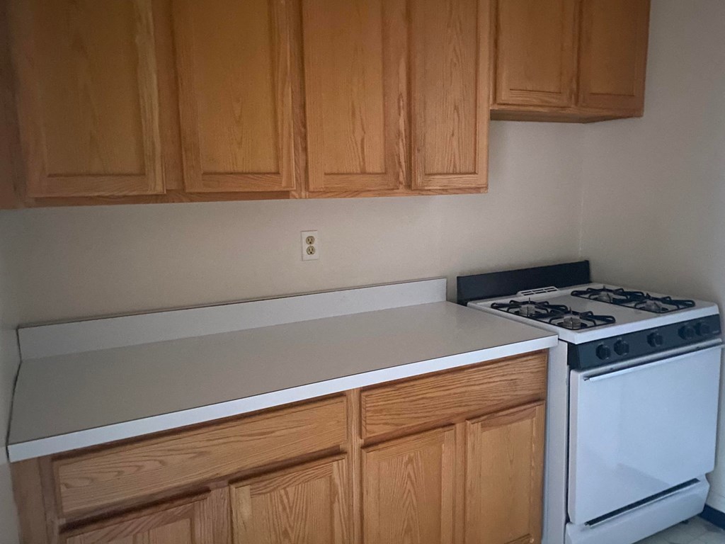 a kitchen with white appliances and wooden cabinets