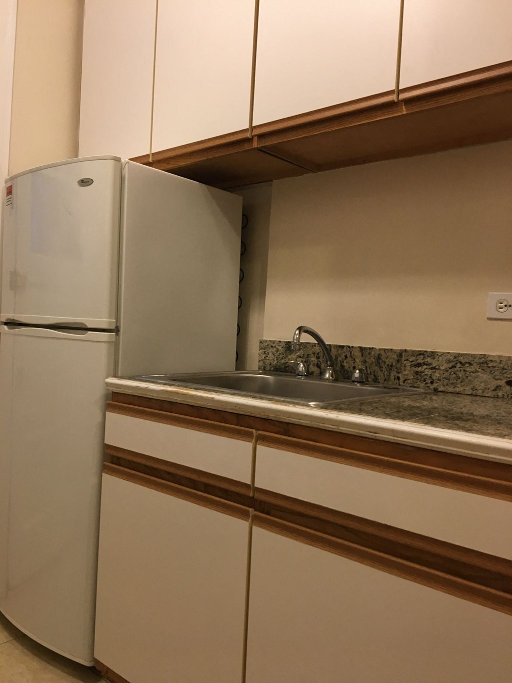 a kitchen with white cabinets and a sink and a refrigerator
