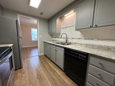 A kitchen with a black oven and a white fridge.