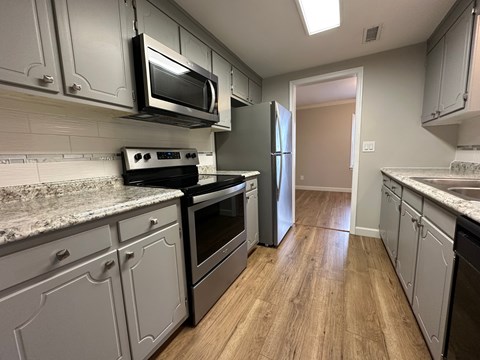 A kitchen with a stove top oven and a microwave.