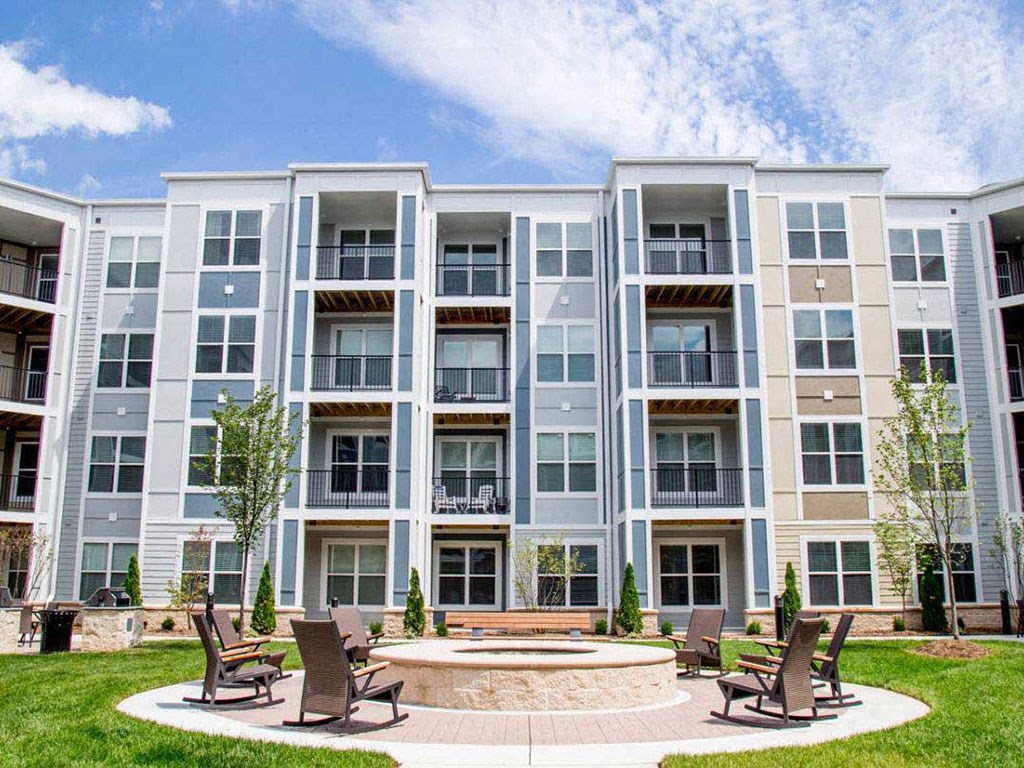 a courtyard with a fountain in front of an apartment building