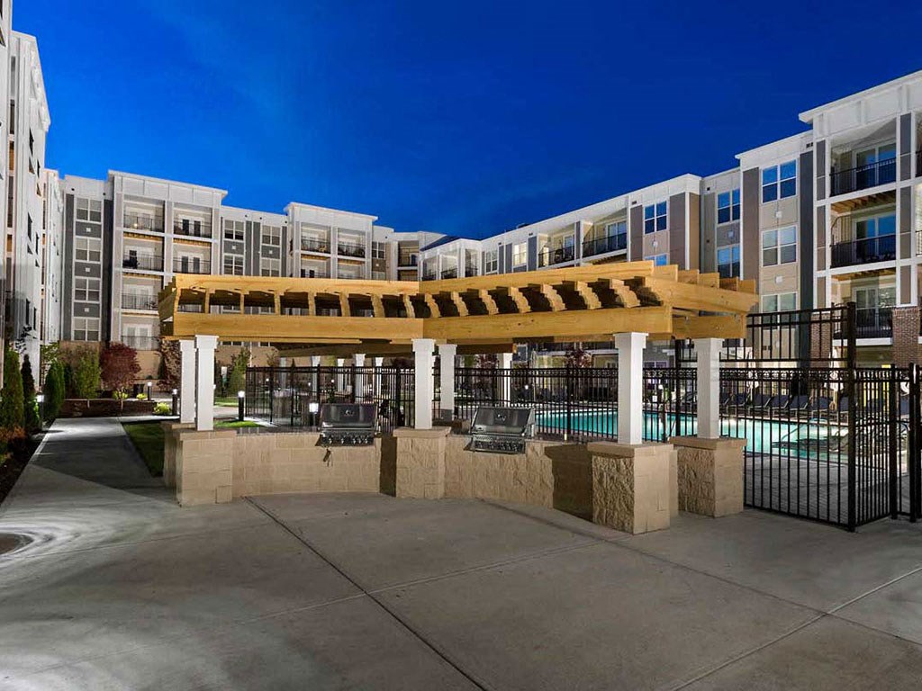 a building with a pool and awning in front of it