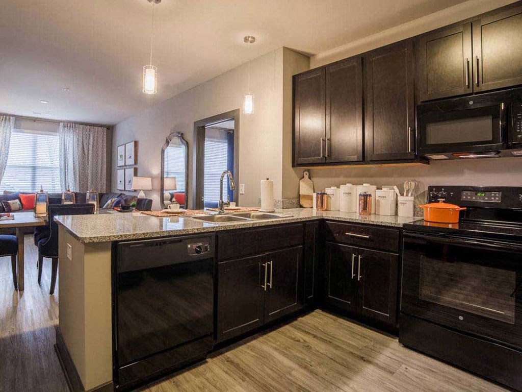 a large kitchen with black cabinets and a counter top