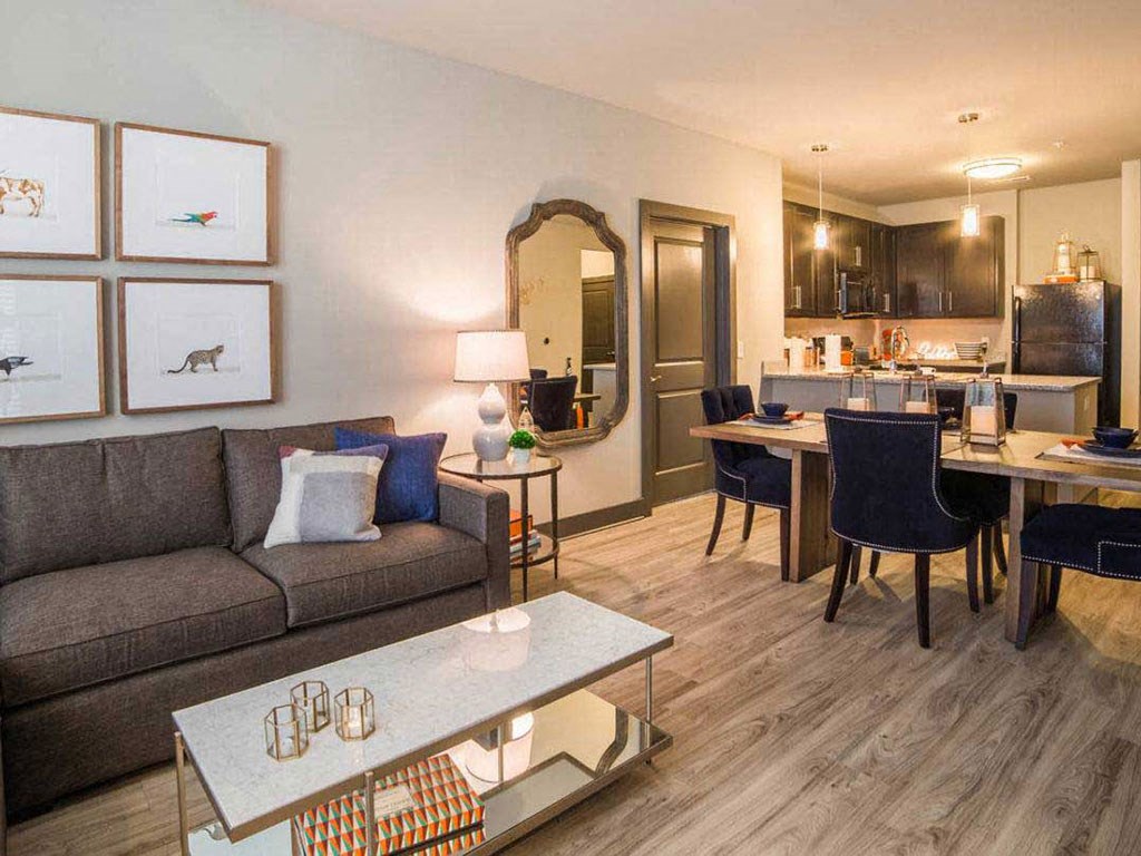 a living room and kitchen with a couch and a table